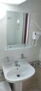 a bathroom with a white sink and a mirror at Hotel Botanical in Samarkand +36 photos