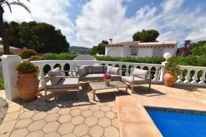 a patio with chairs and a pool in front of a house at Casa Maya in Benissa