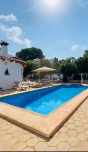 a swimming pool in front of a villa at Casa Maya in Benissa