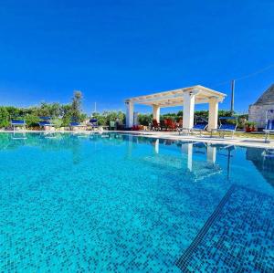 a large swimming pool with a gazebo at Trulli Pax Animi in Martina Franca