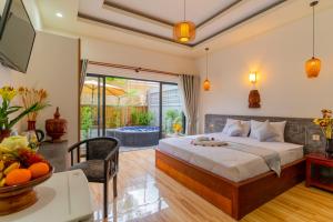 a bedroom with a bed and a living room with a tub at Angkor Rithy Residence 2 in Phumĭ Réach Born (1)