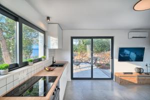 a kitchen with large windows and a view of a patio at Holiday house Sunset Haven Estate in Sutivan