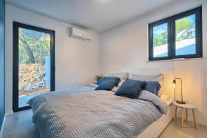 1 Schlafzimmer mit einem großen Bett und 2 Fenstern in der Unterkunft Holiday house Sunset Haven Estate in Sutivan