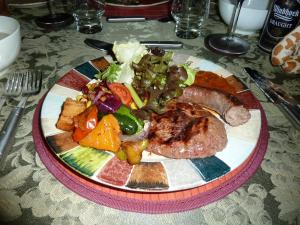 ein Teller mit Fleisch und Gemüse auf dem Tisch in der Unterkunft Muweti Bush Lodge in Grietjie Game Reserve