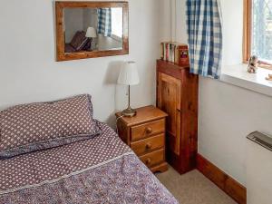 a bedroom with a bed and a mirror and a dresser at Hunt Cottage in Sharrington