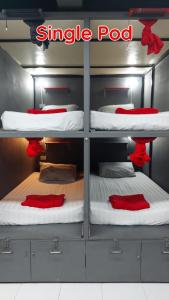 Cette chambre comprend 3 lits superposés avec des draps rouges. dans l'établissement Dormsin Social, sur les Îles Phi Phi