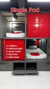 Cette chambre comprend 3 lits superposés avec un panneau rouge. dans l'établissement Dormsin Social, sur les Îles Phi Phi
