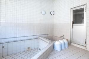 リバーサイドひの في Hino: حمام ابيض مع حوض استحمام ودورتين مياه