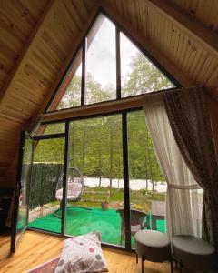 Cette chambre dispose d'une grande fenêtre offrant une vue sur la piscine. dans l'établissement Lelvani Suite Bungalow, à Rize