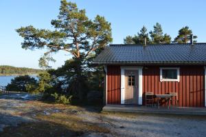 a red and white cabin with a table and a window at Vuosnaisten Meriasema in Kustavi