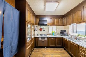 a kitchen with wooden cabinets and a sink at Wabi Sabi Hostel in Tokyo