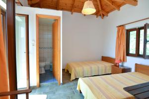 a bedroom with two beds and a bathroom at Astros Beach house within an olive farm in Astros