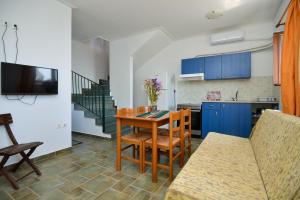 a living room with a table and a kitchen at Astros Beach house within an olive farm in Astros