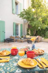 een tafel met borden eten erop bij Maison d'hôtes ÔVillage in Ouveillan