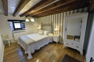 a bedroom with a white bed and a mirror at Casa Rural El Rotejar in El Royo