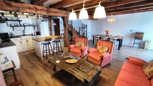 a living room with a table and chairs and a kitchen at Casa Rural El Rotejar in El Royo