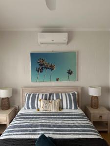 a bedroom with a bed with palm trees on the wall at Saltys 4BRM Beachfront WIFI Pet Friendly in Victor Harbor