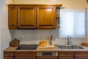 una cucina con mobili in legno e un lavello di Yiolanda Pool Villa by "Elite" a Città di Zante Altre 40 foto