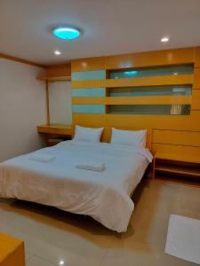 バンコクにあるLove mansionの木製のヘッドボードが付いた大きなベッドのある寝室