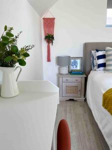 a bedroom with a bed and a table with a plant at The Loft Curracloe, on Wexfords Coastal Scenic Route in Wexford