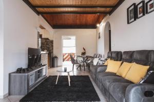a living room with a couch and a tv at La Kaz en lèr - Calme et Vue - idéal Randos in Le Tampon