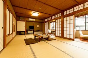 a large room with a table in a room with windows at Yoshiharu in Toyooka