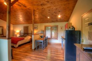 cocina y dormitorio con cama y nevera. en Sleepy Hollow, en Boone