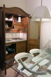 イモラにあるAtelier Della Castellina - SELF CHECK INのキッチン(白い椅子2脚、ガラスのテーブル付)