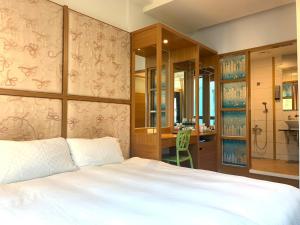 una camera da letto con un letto, una scrivania e un bagno di Happiness Inn a Kenting