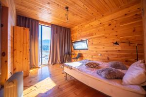 Shkaleri的住宿－Svaneti Сountryside 1，一间带木墙的卧室和一张位于客房内的床