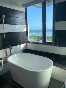 a white bath tub in a bathroom with a window at Happiness Inn in Kenting