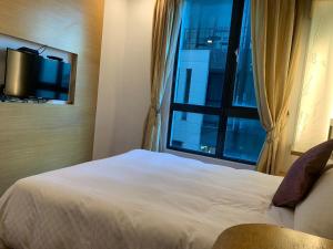 una camera da letto con un letto bianco e una finestra di Happiness Inn a Kenting