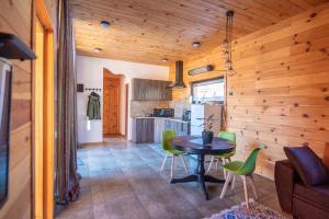 Shkaleri的住宿－Svaneti Сountryside 1，厨房以及带桌子和绿色椅子的用餐室。