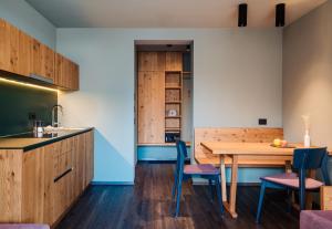 una cucina e una sala da pranzo con tavolo e sedie in legno di Max Green Forest Apartments a Siusi
