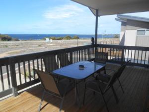 a blue table and chairs on a balcony with the beach at The White House - Edithburgh in Edithburgh