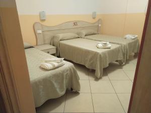 a hotel room with two beds with towels on them at Hotel Sagittario in San Sperate