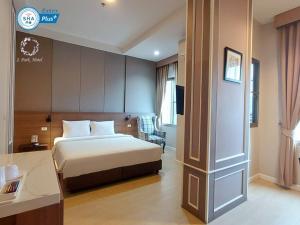 a hotel room with a bed and a desk at J Park Hotel - SHA Extra Plus in Chon Buri
