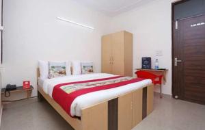 a bedroom with a large bed and a red desk at POP 81169H Sunview Stay in Gurgaon
