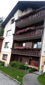 a building with a balcony with flowers on it at Ferienwohnungen Miklautsch in Faak am See