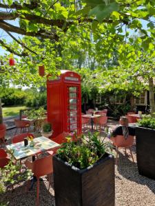 een rode telefooncel in een tuin met tafels en stoelen bij Ruime chalet nabij Giethoorn in De Pol