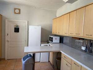 a kitchen with a counter and a white refrigerator at Maison Althea Rosea - 3 chambres et piscine in Nieulle-sur-Seudre
