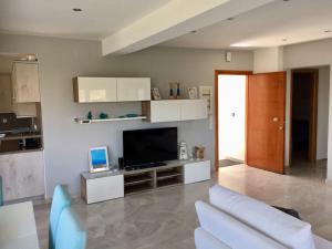 a living room with a couch and a television at Luxury Villa by the Sea in Volos