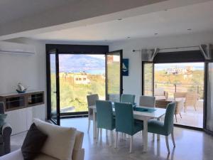 comedor con mesa y sillas y cocina en Luxury Villa by the Sea en Volos