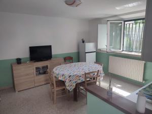 a kitchen with a table and a television and a table and chairs at Casa Venezia in Senigallia