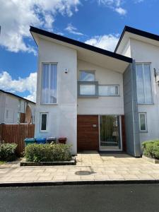 a large white house with a fence in front of it at Nice house + Car parking + Close to the city centre in Manchester