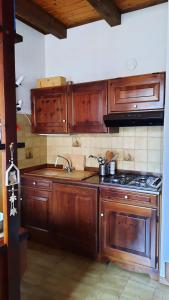 La casa del Cucù al Ravascletto, 900mt from cable car في رافاسكليتو: مطبخ بدولاب خشبي وموقد +18 صورة