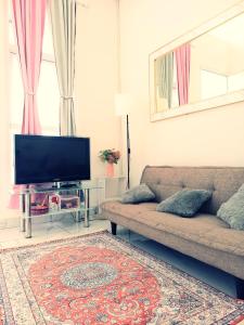 sala de estar con sofá y TV de pantalla plana en Townhouse MisNov good escape from Jakarta, 