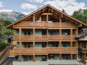een groot huis met houten balkons aan de zijkant bij Max Green Forest Apartments in Siusi