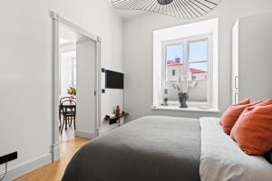 a white bedroom with a bed and a window at Brand New Old Town Apartment With Terrace in Haapsalu