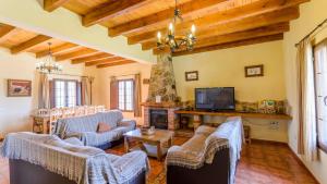 ein Wohnzimmer mit Sofas und einem TV in der Unterkunft Casa Loma el Letrao Almogia by Ruralidays in Almogía